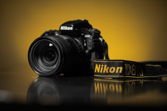 Nikon brand DSLR camera with lens and strap on a table