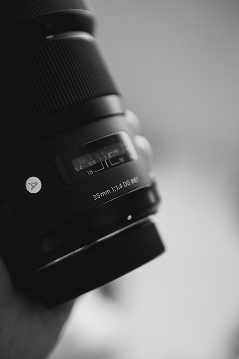 Close-up of a hand holding a Sigma brand lens