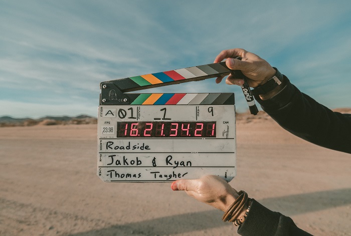 a production assistant holds a clapperboard before beginning a film shoot