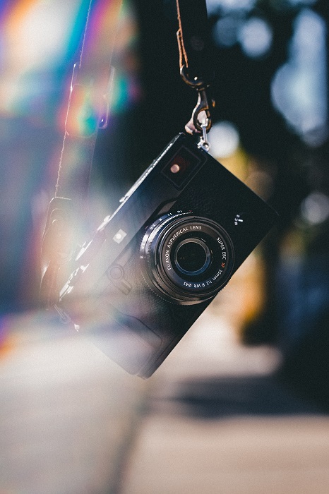 a camera hangs from its strap in a funky lighting environment