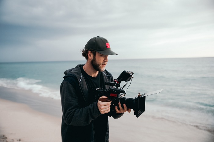 a photographer uses a big bulky camera on the beach