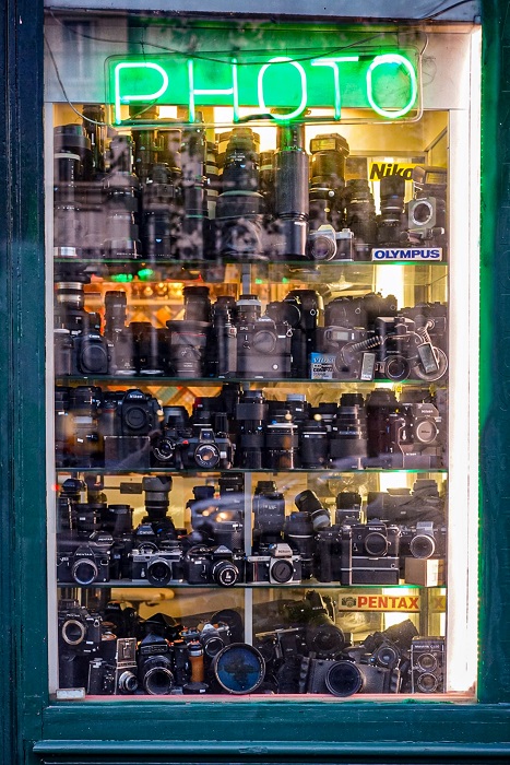 a photography storefront window with neon PHOTO sign