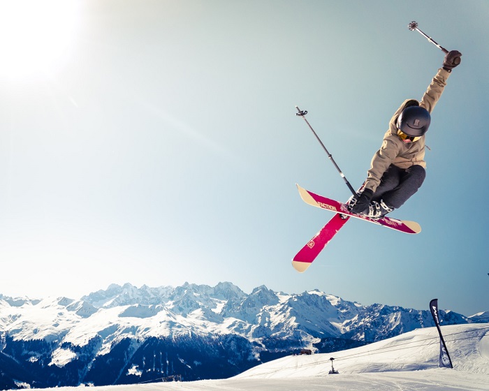 an action shot of a skier getting air in front of a mountain range in the distance 