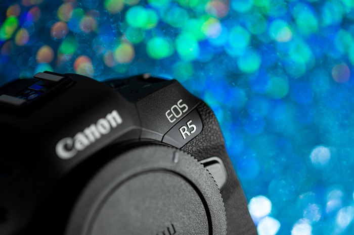 the Canon EOS R5 in front of an out of focus neon background