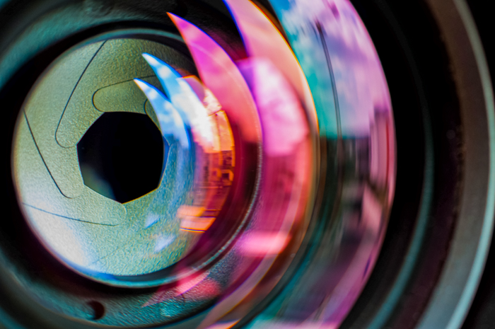 Close-up of camera lens with colorful reflections