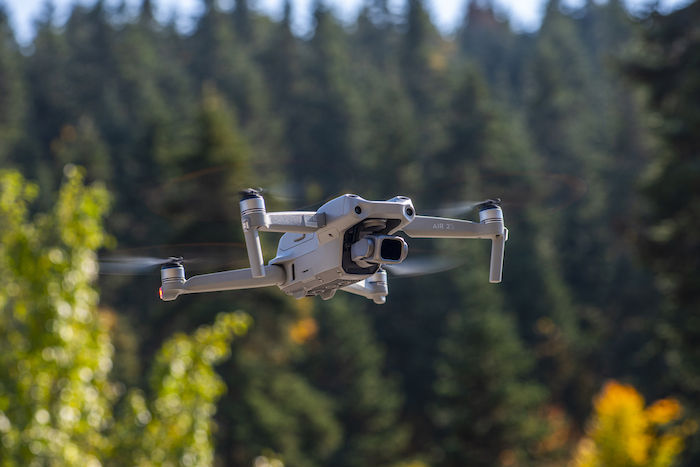 DJI Air 2S Drone flying with green background.