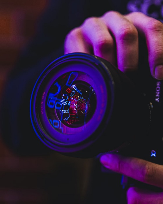 Person taking photo with Sony camera in neo lights